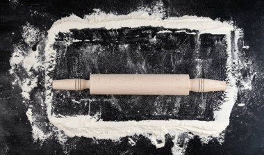 siyah bir arka plan üzerinde ahşap oklava, üst görünüm