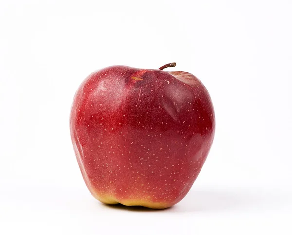 Красное спелое яблоко с дефектами на белом фоне — стоковое фото
