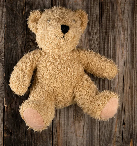 Kleine bruine oude teddybeer, grijze oude houten achtergrond — Stockfoto