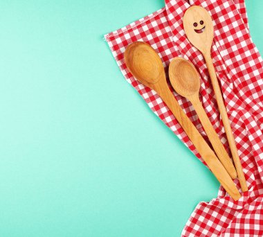 kırmızı bir mutfak havlusu üzerine oyma yüz ile ahşap kaşık