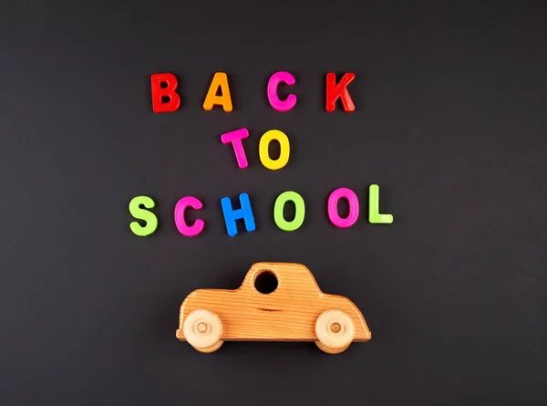 Voiture bébé en bois sur tableau noir, concept retour à l'école — Photo