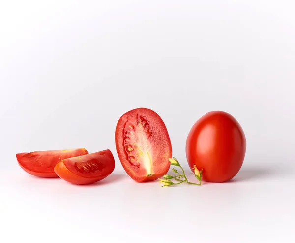 Tomates enteros rojos maduros y trozos sobre un fondo blanco — Foto de Stock