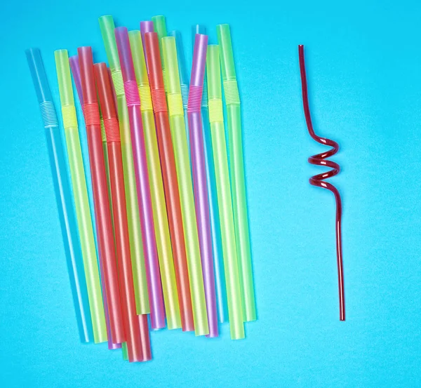 Multi-colored plastic tubules for cocktails on a blue background — Stock Photo, Image