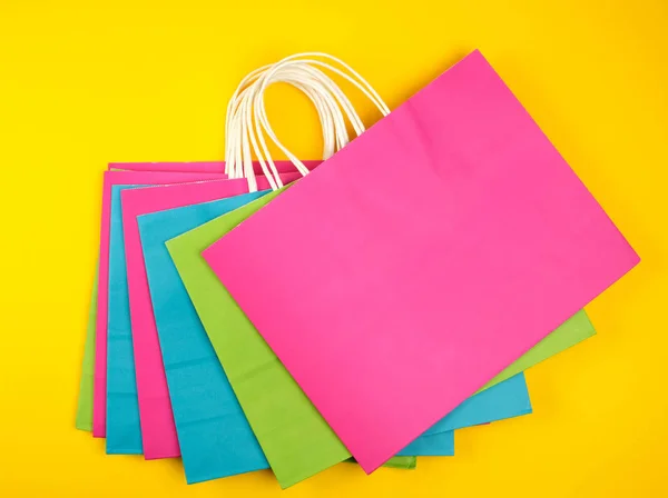 Sacos de compras de papel multicoloridos retangulares com alças brancas — Fotografia de Stock