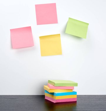 siyah ahşap bir masa üzerinde çok renkli yapışkan çıkartmalar yığını