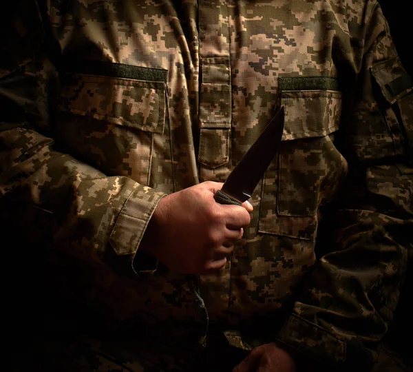 Солдат, одягнений у військову форму, тримає гострий тактичний ніж — стокове фото