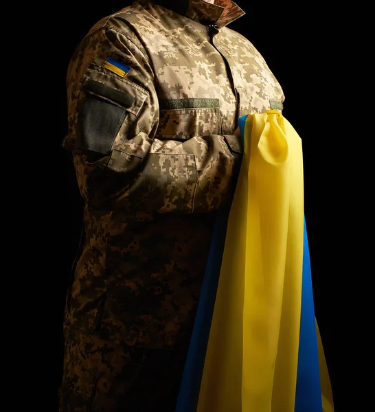 Український солдат тримає в руці жовто-блакитний прапор — стокове фото