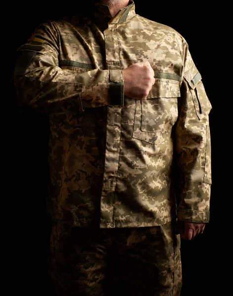 Soldado ucraniano vestido de uniforme se para en la oscuridad y poner — Foto de Stock
