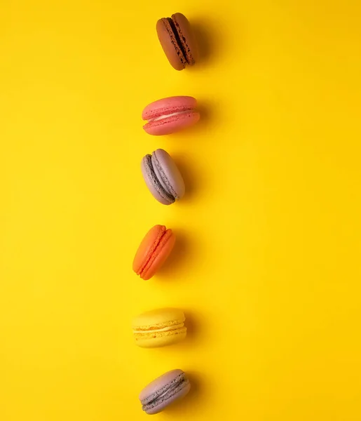 Assortiment de macarons ronds multicolores cuits au four sur un bac jaune — Photo