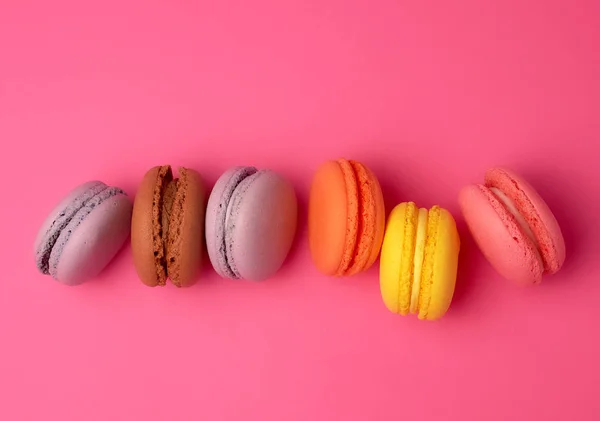 Kleurrijke gebakken Macarons amandelmeel op een roze achtergrond — Stockfoto