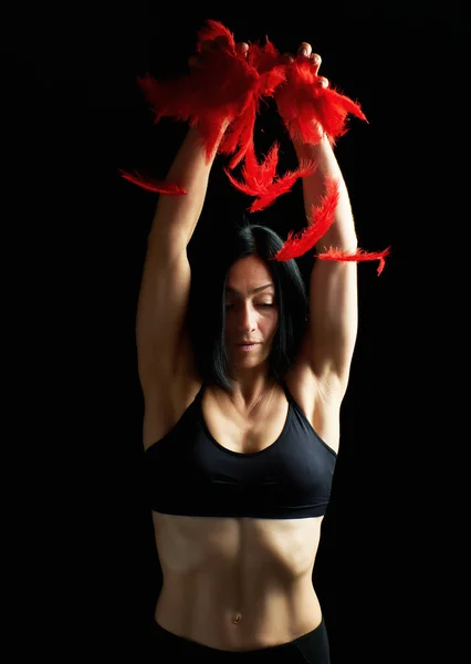 年轻的 美丽的 运动 女孩 在 黑色 衣服 抛出 红色 fea — 图库照片