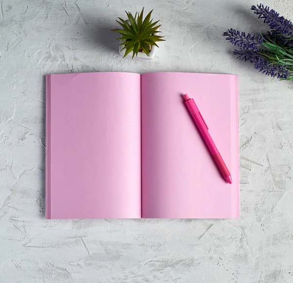 open notebook with blank pink pages, red pencil and a bouquet of