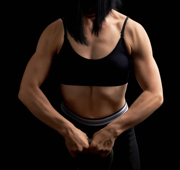 Fille d'apparence athlétique tient une kettlebell en fer devant — Photo