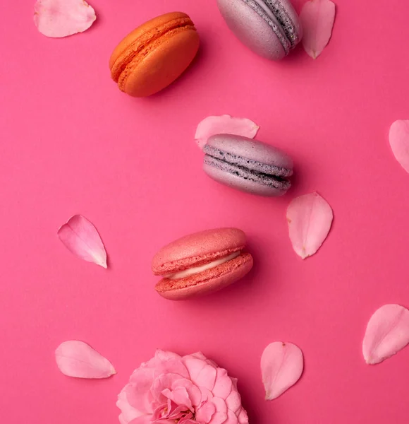 Macarons multicolores sucrés à la crème et un bourgeon rose rose avec — Photo