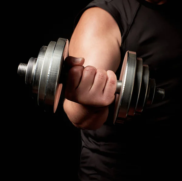 Mano de un hombre con bíceps grandes sostiene una mancuerna de acero — Foto de Stock