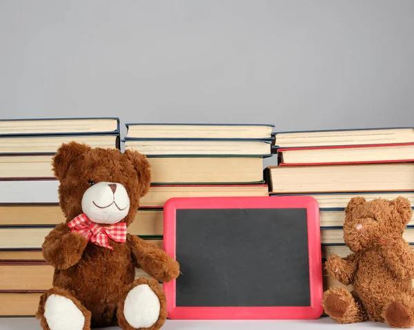 brown teddy bear and empty black board in red frame on the backg