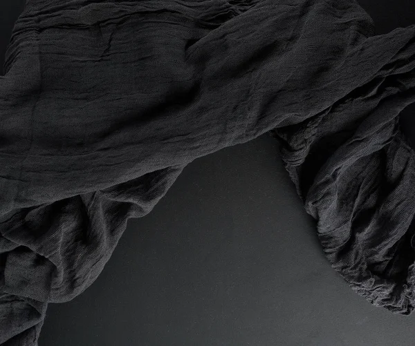 Измятая черная марля ткани на черном фоне — стоковое фото