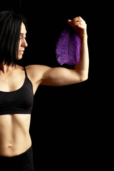 Junge Frau mit sportlicher Figur und schwarzgekleideten Muskeln — Stockfoto