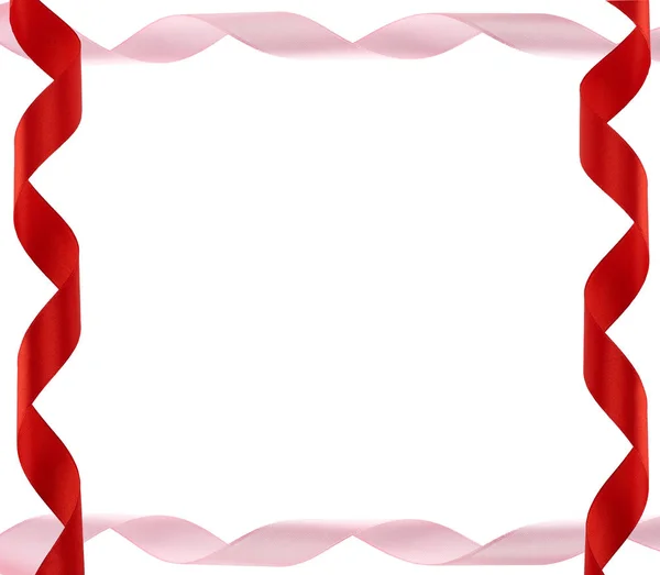 Изогнутые красные и розовые атласные ленты на белом фоне — стоковое фото