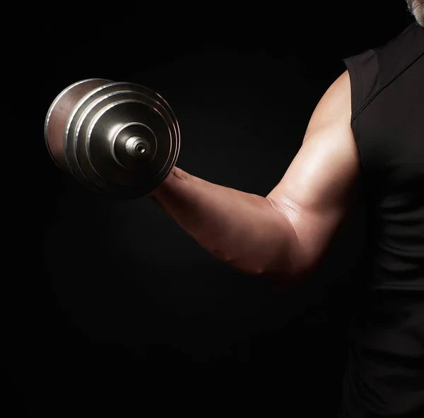 Mano de un hombre con bíceps grandes sostiene una mancuerna de acero — Foto de Stock