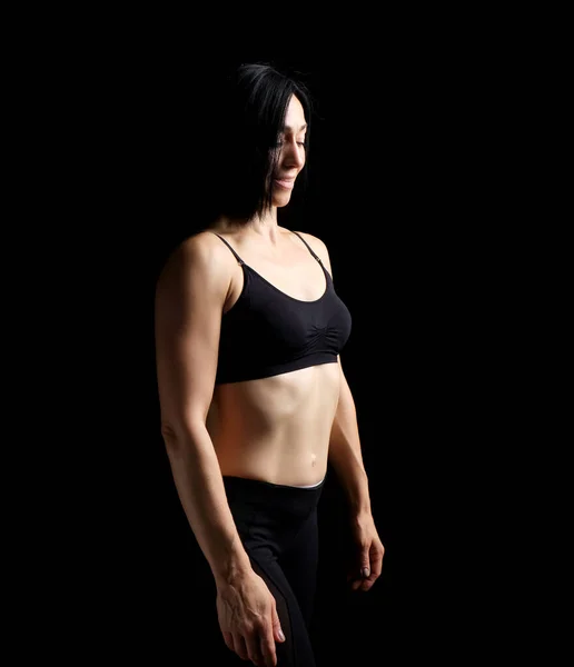 Adult girl with a sports figure in black bra and black shorts st — Stock Photo, Image