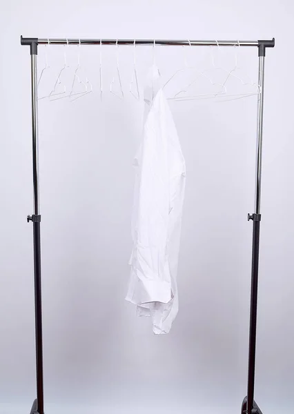 Biała męska pognieciona koszula zawieszona na metalowym wieszaku — Zdjęcie stockowe