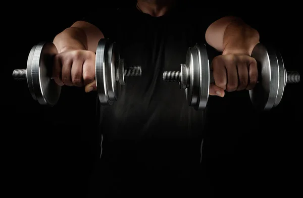 Two steel typesetting dumbbells in male hands, sports backdrop — Stock Photo, Image