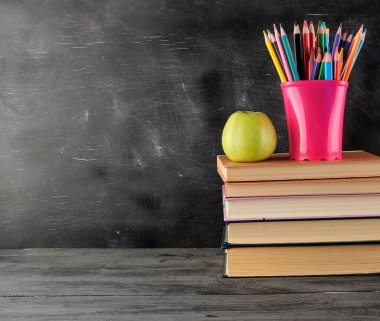 Bir yığın kitap ve çok renkli tahta kalemler.