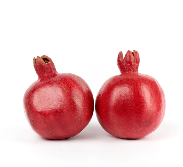 Два спелых красных граната в кожуре на белом фоне — стоковое фото