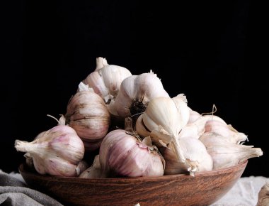 Kahverengi bir tabakta soyulmamış sarımsak. 