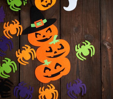 Örümcek ve turuncu balkabağı kahverengi arkaplandaki figürleri hissetti