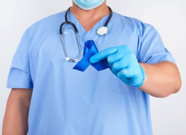 Mavi üniformalı doktor ve steril lateks eldivenli doktor koyu bir blu tutuyor.