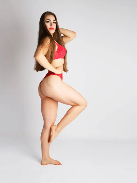 Menina bonita com uma figura fina vestida com lingerie de renda vermelha — Fotografia de Stock