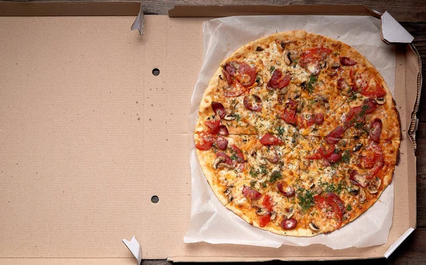Pieczona pizza okrągła z wędzonymi kiełbaskami, grzybami, pomidorami, che — Zdjęcie stockowe