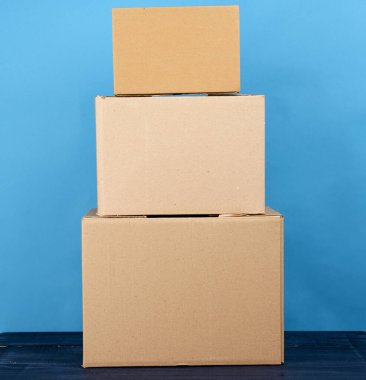 Mavi ahşap bir masa üzerinde kahverengi kraft kağıt karton kutular, hareket konsepti