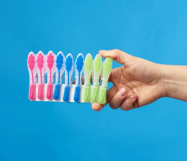 Hand Holds Stack Multi Colored Plastic Clothespins Blue Background — Stock Photo, Image