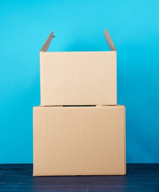 Mavi ahşap bir masa üzerinde kahverengi kraft kağıt karton kutular, hareket konsepti