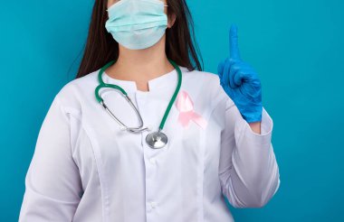 Ekim 'de göğüs kanseriyle mücadelenin sembolü olan beyaz bir cekete takılan pembe ipek kurdele. Terapist ellerini kaldırdı ve işaret parmağı dikkatli olduğunu gösteriyor. 