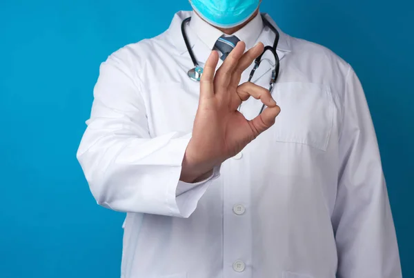 白いコートの男医師は手でOkジェスチャーを示していますすべてがうまくいくという希望の概念青の背景 — ストック写真