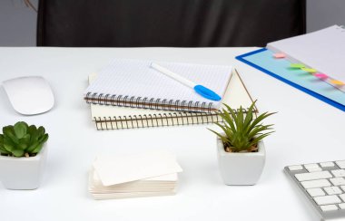 Kahverengi deri koltuk, kırtasiyeli beyaz masa, kağıt defter. Bir liderin, işadamının işyeri.