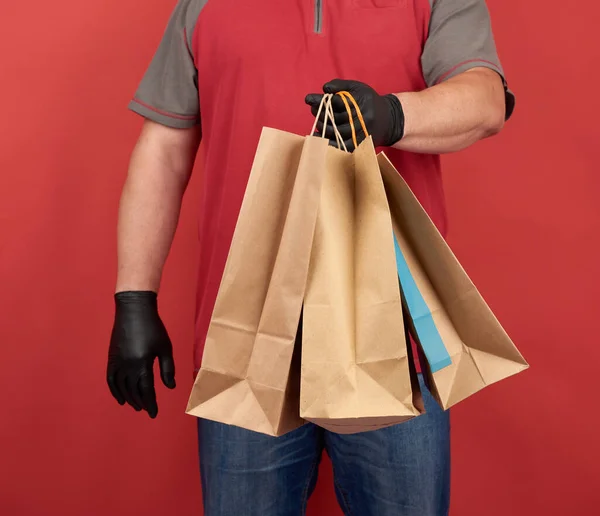 Férfi Piros Pólóban Fekete Latex Kesztyűt Visel Papírzacskót Tart Vásárláshoz — Stock Fotó