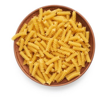 Kahverengi kil tabakta çiğ fusilli makarna beyaz zemin üzerinde izole, üst görünüm