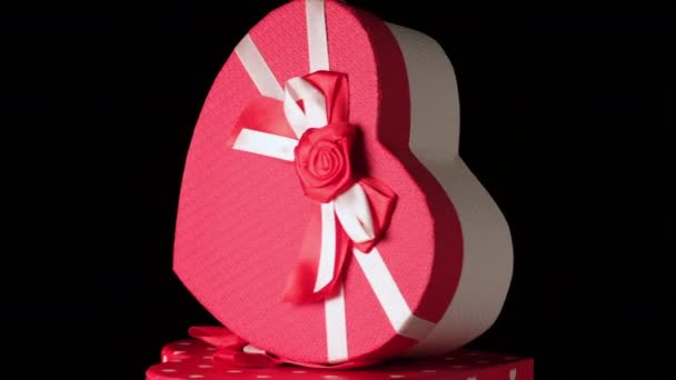 红色心形纸盒 底色为黑色 有蝴蝶结 节日礼物转过来 — 图库视频影像