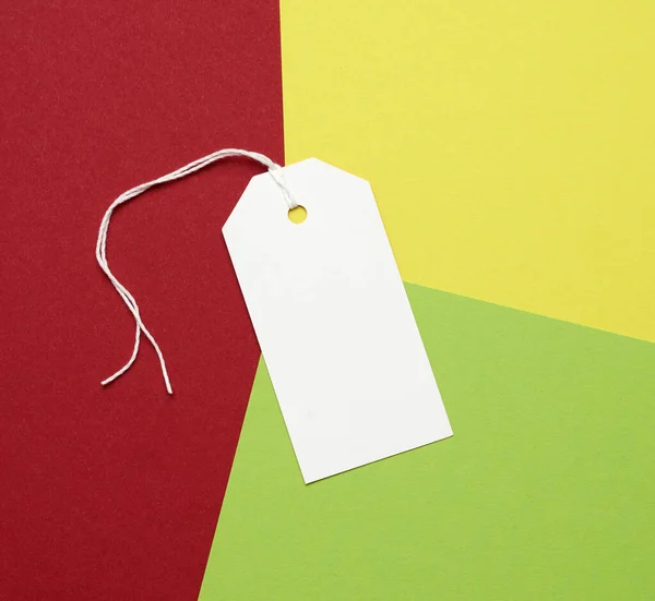 Étiquette Rectangulaire Papier Blanc Sur Une Corde Sur Fond Coloré — Photo