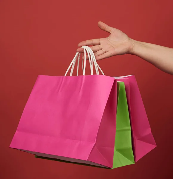 Mujer Sostiene Pila Bolsas Papel Sobre Fondo Rojo Concepto Compras — Foto de Stock