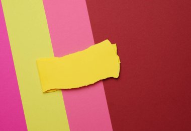 Renkli arkaplanda yırtık sarı kağıt parçası, soyut arkaplan, kapat