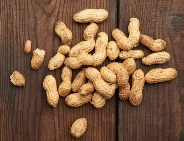 Ongeschilde Pinda Een Houten Tafel Lekker Gezond Fruit Bovenaanzicht — Stockfoto