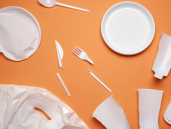 Used Plastic Dishes Pieces Plastic White Plastic Bag Orange Background — Stock Photo, Image