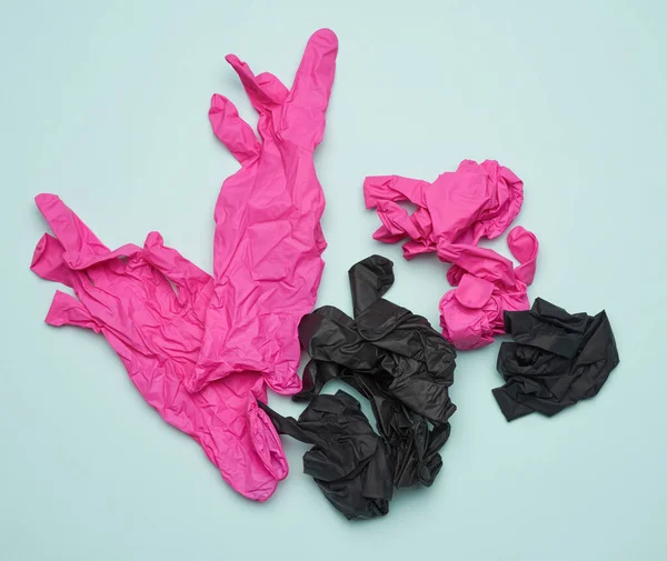 蓝色背景的黑色和粉色乳胶手套 可回收垃圾 顶视图 — 图库照片