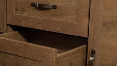 Kadın elleri kirli çamaşırları kahverengi ahşap çekmece çekmecesine atar. Dağınıklık kavramı, ihtiyaç fazlası.